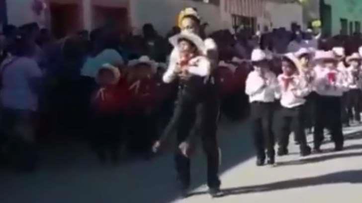 Maestra ayuda a bailar a niño con discapacidad en desfile