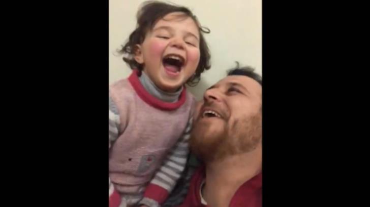 Padre sirio enseña a su hija a reírse, en medio de un bombardeo ruso