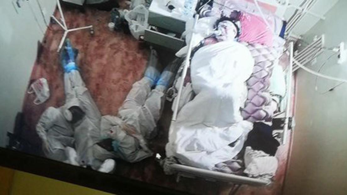Médicos descansan en el suelo junto a cama de paciente con Covid-19 tras noche en vela
