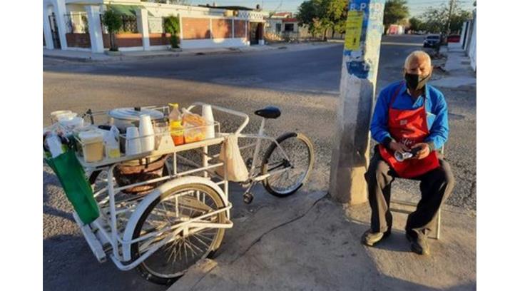 Don Raúl empuja su carrito de elotes con las ganas de llevar sustento a su hogar