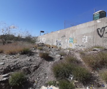 Reportan terreno baldío invadido de basura e indigentes