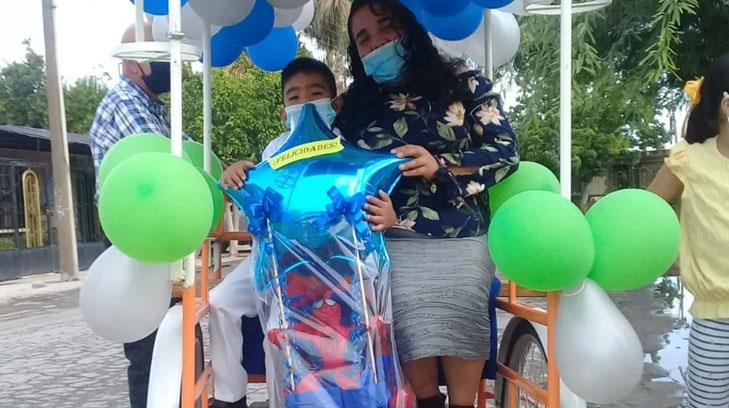 Ni la lluvia detuvo que el pequeño Elías llegara en su triciclo a la caravana de graduación