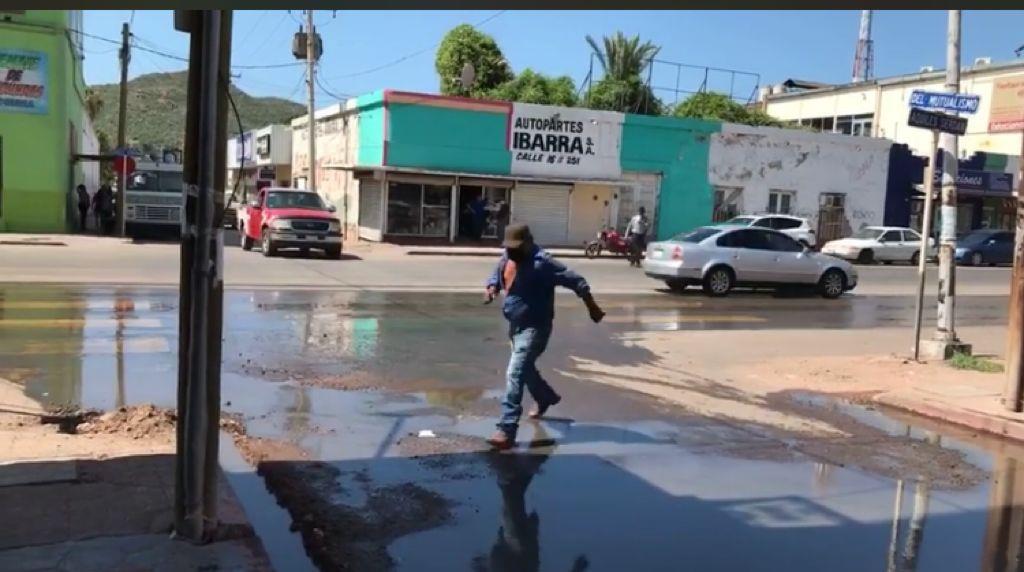 A brincos cruzan los guaymenses esta calle del Centro por fuga de drenaje