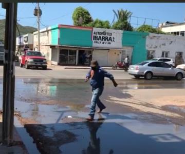 A brincos cruzan los guaymenses esta calle del Centro por fuga de drenaje