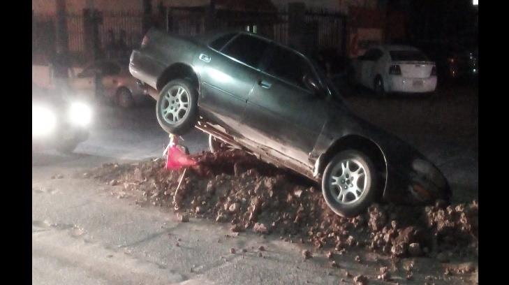 Con las llantas rodando queda automóvil al caer en hoyo que dejó la CEA en Guaymas