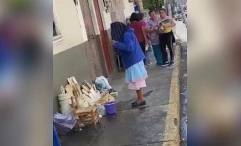 VIDEO INDIGNANTE - Le echan agua a ancianita que vendía sus artesanías en la banqueta para que se quite