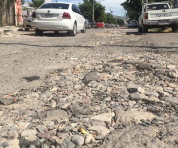Es la única manera; vecinos llenan calles de escombros para tapar baches de Hermosillo