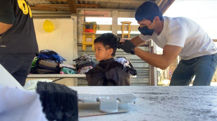 De buen corazón cortan el pelo y regalan ropa a niños de la invasión Guayacanes